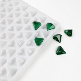 Close-up of a 2mL diamond gummy mold with 179 cavities and emerald green gummies on a white background