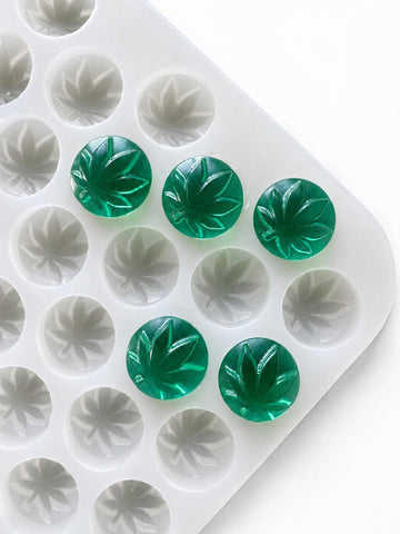 Angled product photo of a 3.1mL leaf gummy mold with 185 cavities and emerald green leaf gummies