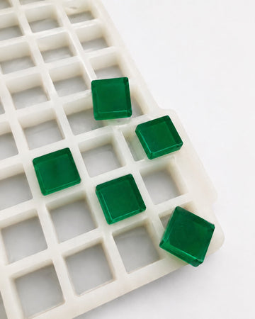 Angled view of a 3.2mL cube gummy mold with 270 cavities and emerald green cube gummies on a white background
