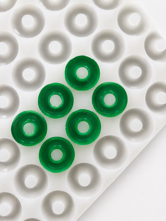 Close-up of the 3.4mL 108-cavity peach ring gummy mold showing emerald green gummy rings and cavity depth
