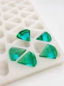 Close angled view of a 3.5mL diamond gummy mold with 173 cavities and emerald green faceted gummies