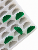 3mL orange slice gummy mold with 140 cavities and translucent emerald green gummy samples on a white background