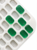 Top-angle view of a 4mL brick gummy mold with 185 cavities and emerald green CBD gummies on a white background